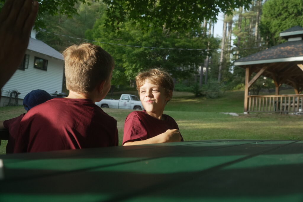 Two campers having fun at a picnic table.