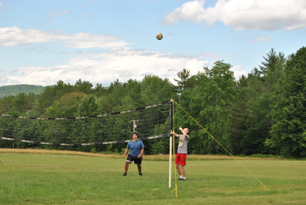 Two boys playing volleyball.
