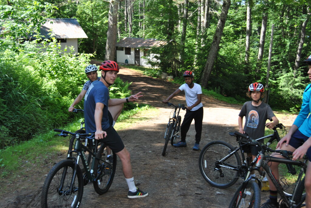 Boys standing with their mountain bikes with their counselors.