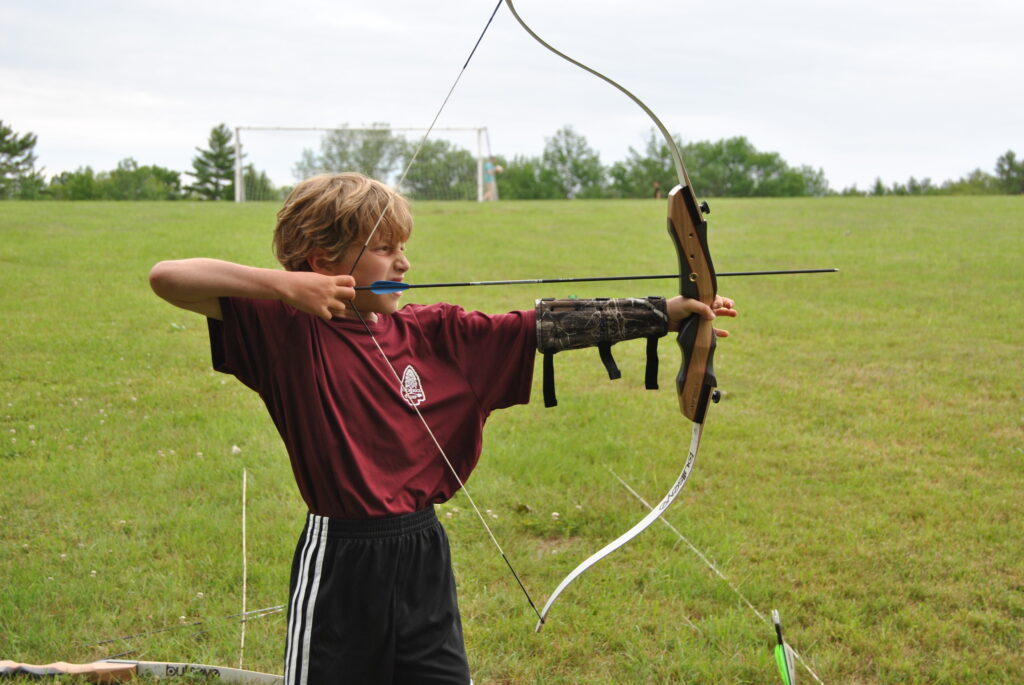 Boy aiming an arrow with his bow