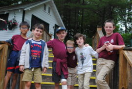 Six young campers standing on the stairs by the office.