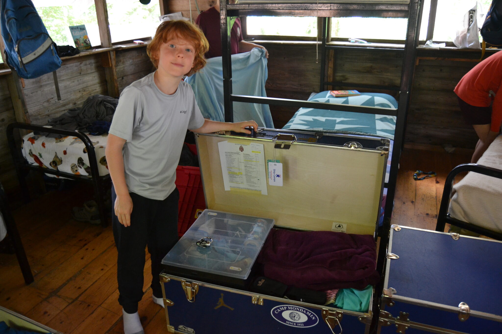 A camper standing next to his organized trunk.