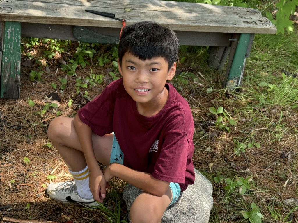 A camper sitting in Campcraft area.