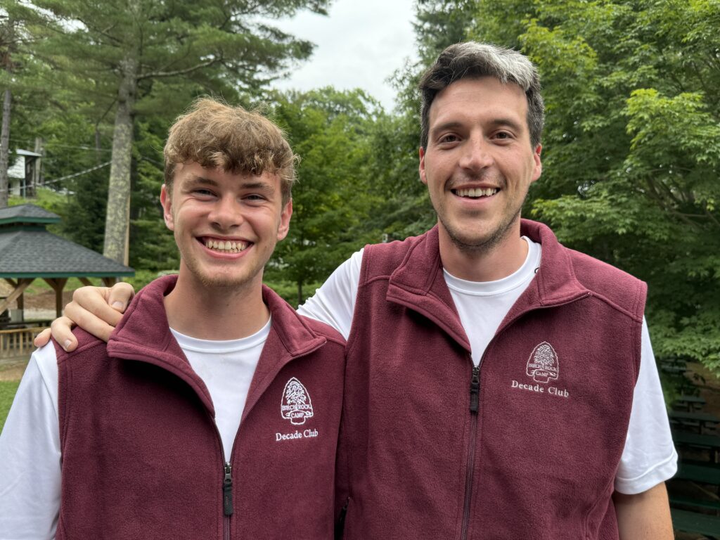 Two staff members wearing their decade vests.