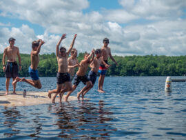 Campers jumping into the lake.