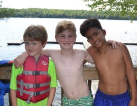 Three campers hanging out at the water front.