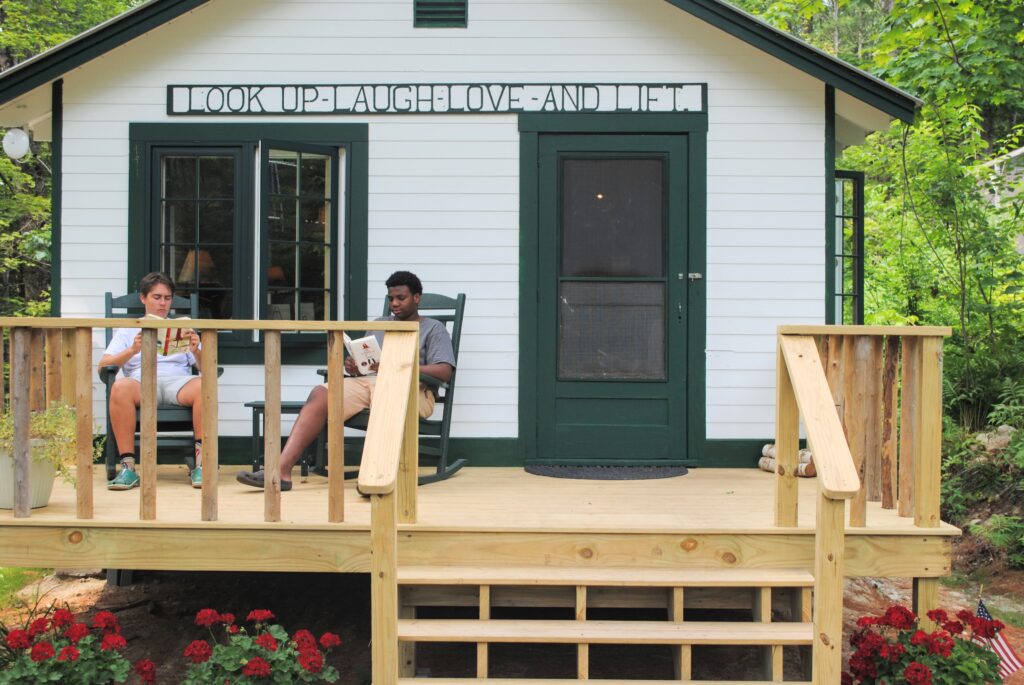 Two campers reading outside of the Birch Rock Library.